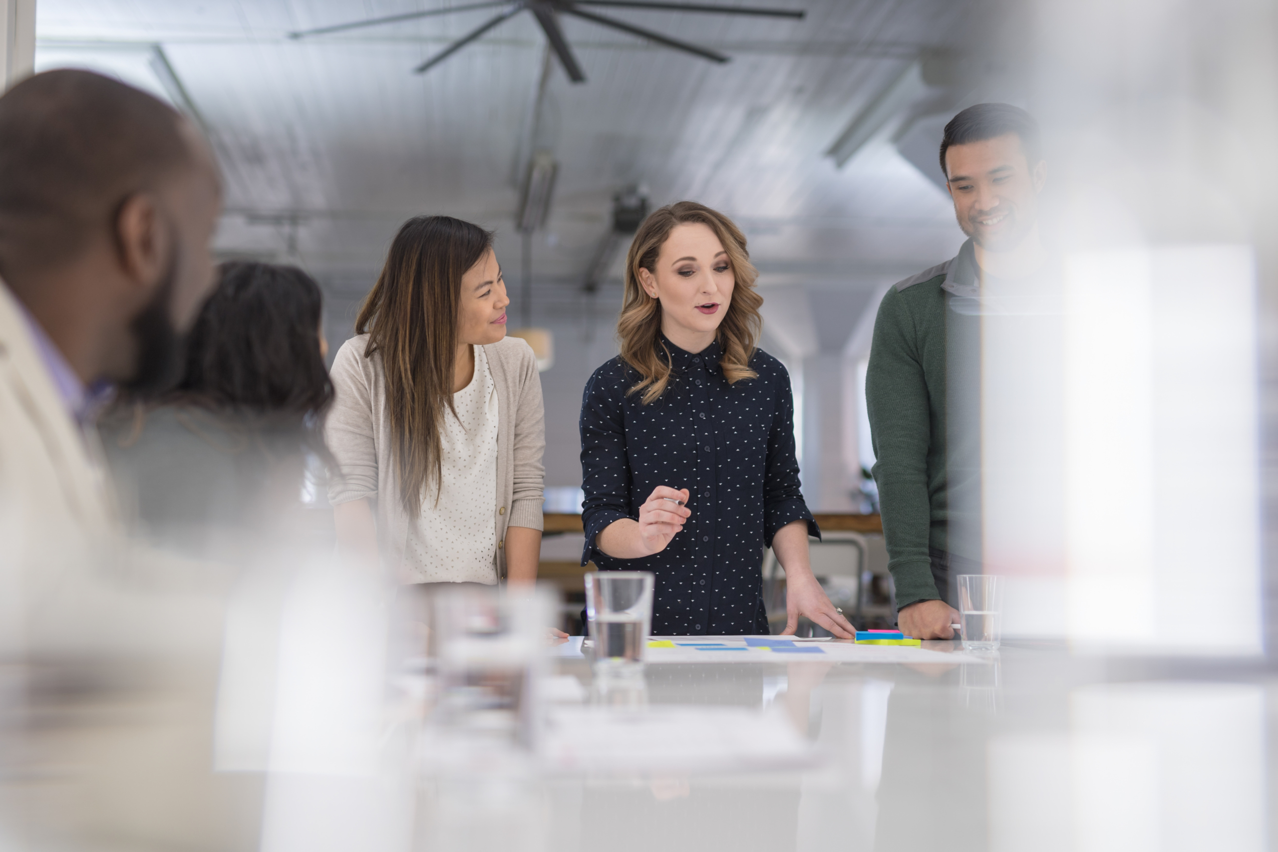A mixed-ethnic group of business colleagues sign paperwork at the conference table Make the Best Value-Based Sourcing Decisions